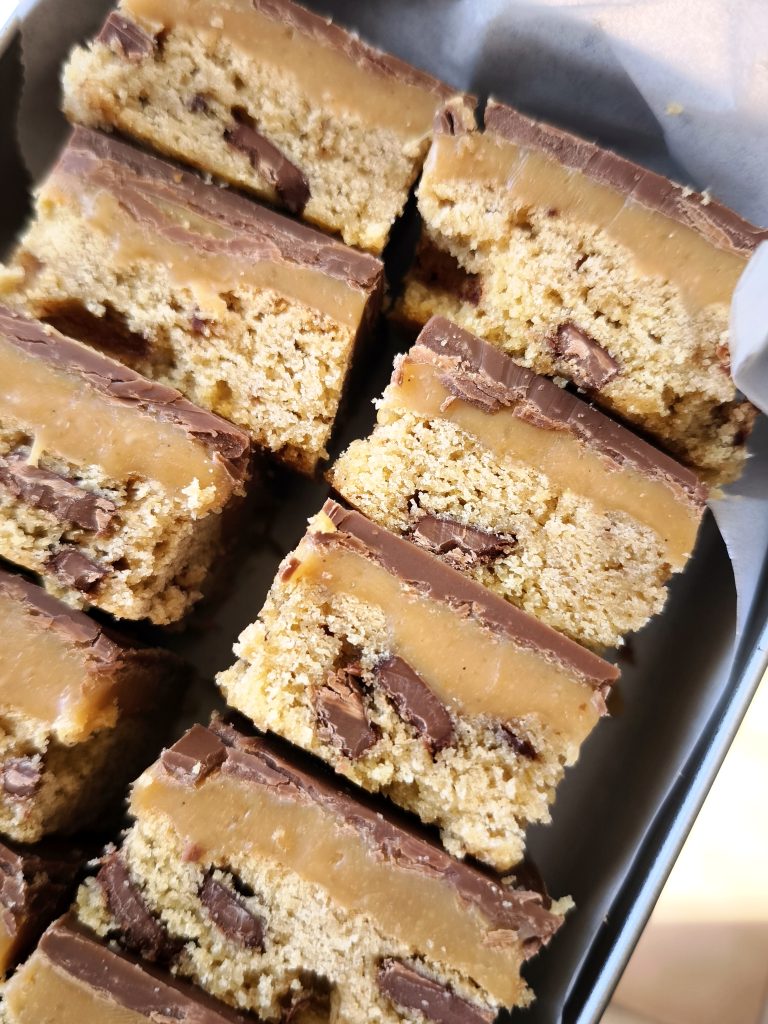 Cookie Millionnaire, caramel et chocolat au lait Morceaux de cookie millionnaire empilés dans une boîte en métal